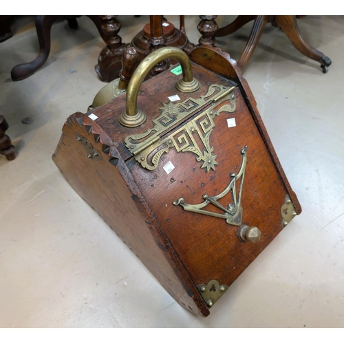 996 - An Aesthetic Movement oak coal scuttle with brass bindings and decoration, with shovel