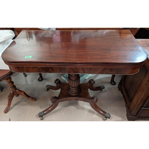 1034 - A mahogany fold over tea table on turned and lobed columns on four splay feet.