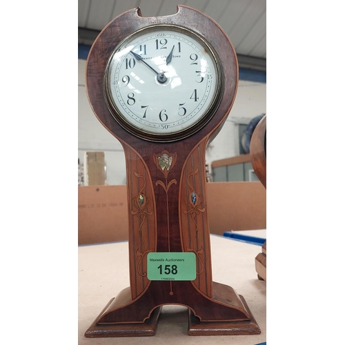 158 - A Liberty style inlaid metal clock with fruitwood and mother of pearl inlay and enamel dial by Manoa... 