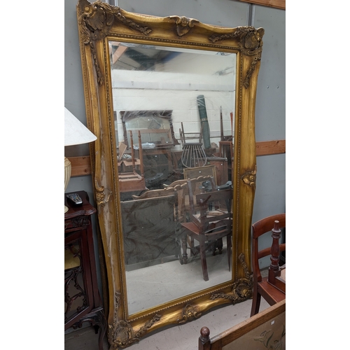 1052 - A very large and impressive gilt framed wall mirror in traditional manner with shell corners, bevell... 