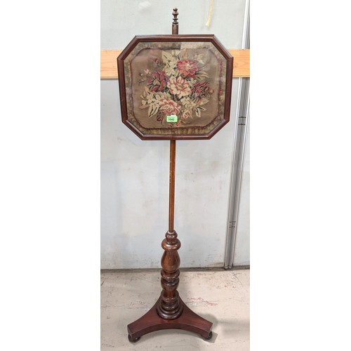 1042 - A 19th century mahogany pole screen with floral tapestry picture in canted glazed square.