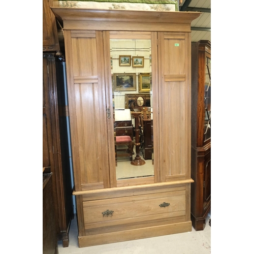 1018 - A stripped mahogany single mirror door wardrobe with drawer below.