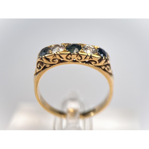 763 - An 18 carat hallmarked gold ring with 3 sapphires and 2 sapphires set alternately, size N/O, 4gm