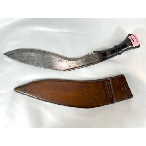 210 - A British military Nepalese fighting Kukri with broad arrow marks to hilt and leather scabbard, with... 