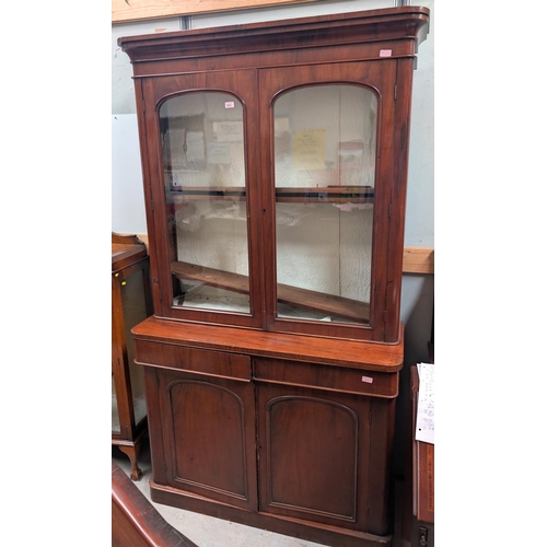 1023 - A 19th century mahogany full height bookcase with panelled doors and two frieze drawers below, glaze... 