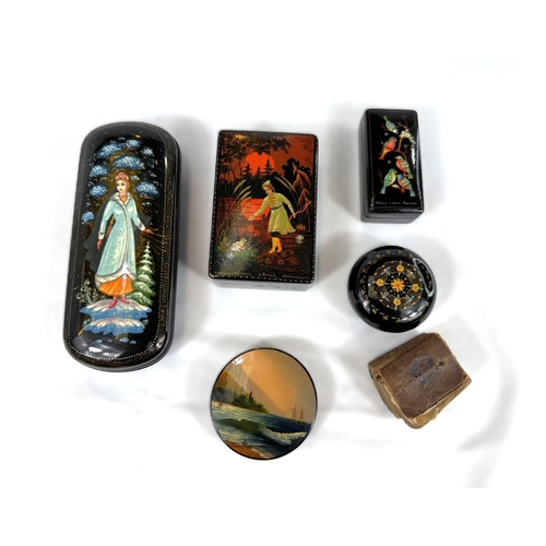 131 - Four USSR lacquer boxes with hand painted and various decoration all with mats to reverse and a glas... 