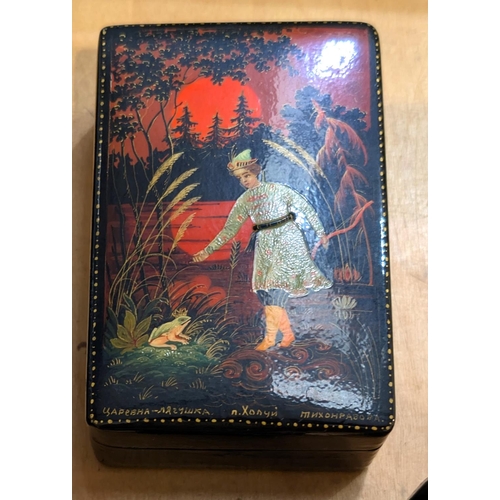 131 - Four USSR lacquer boxes with hand painted and various decoration all with mats to reverse and a glas... 