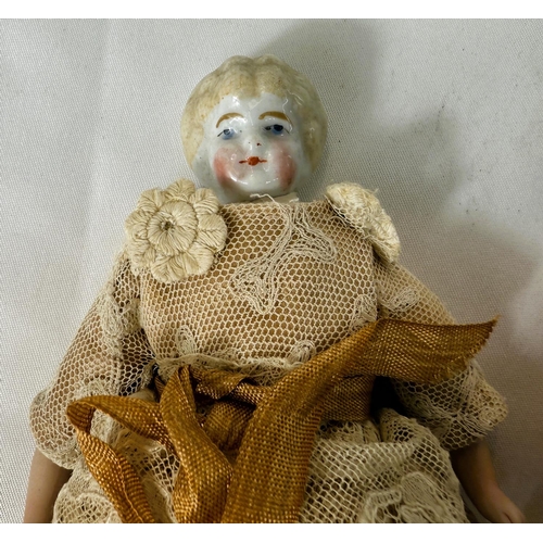 312 - A Norah Wellings vintage cloth doll with cream hat and floral apron, label to foot; a pin cushion do... 