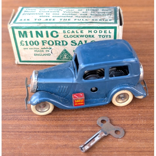 317 - A boxed Minic tin plate clock work £100 Ford saloon with petrol can, blue with white wheels.