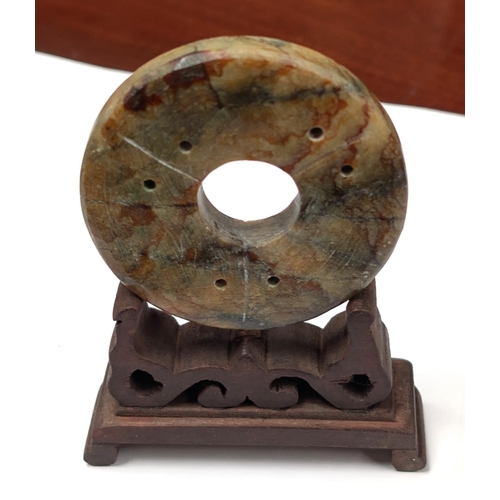 414D - A Chinese carved stone disc with carved stand, dia 6.5cm