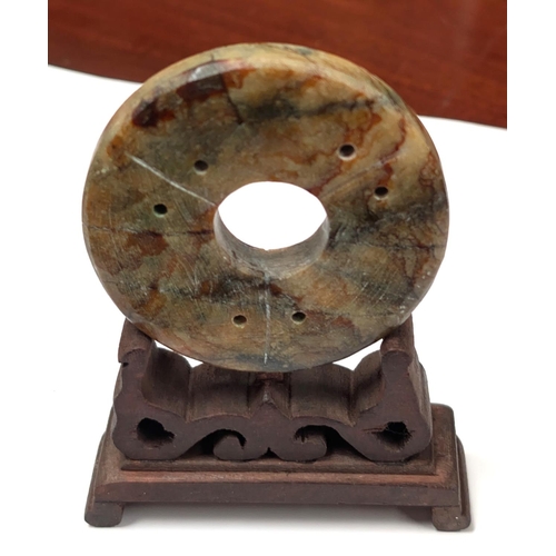 414D - A Chinese carved stone disc with carved stand, dia 6.5cm