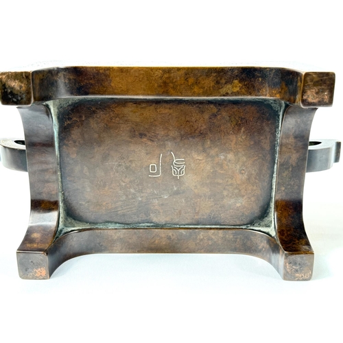 415B - A Chinese bronze censer with inlaid white metal decoration to the body and base, of rectangular form... 