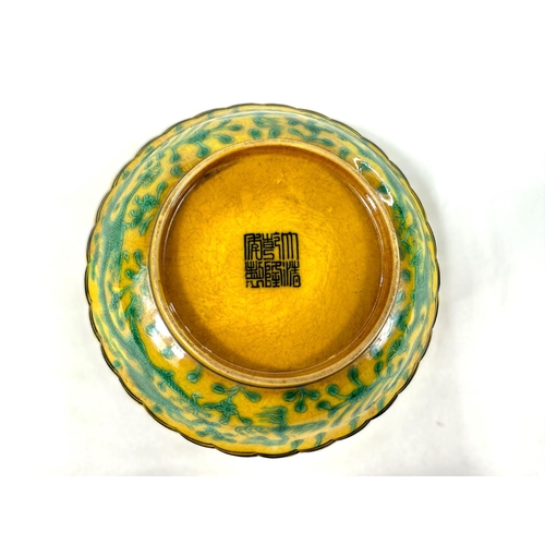 415C - A Chinese yellow ground ceramic dish with green dragon decoration dragons with five claws and seal m... 