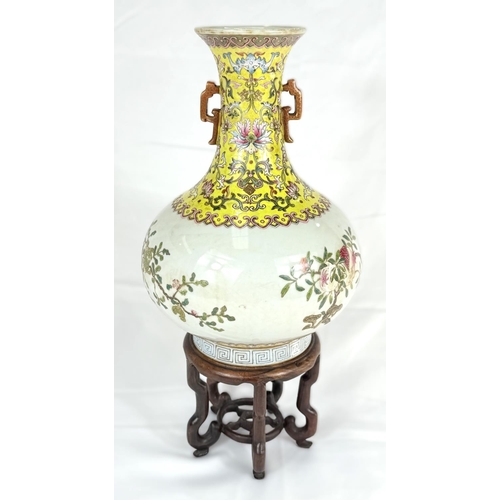 417A - A Chinese squat baluster vase on stand with yellow ground neck and polychrome decoration, of fruits ... 