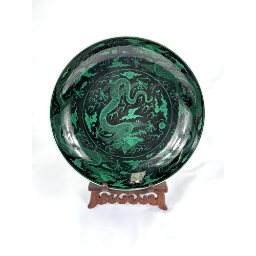 419A - A Chinese black background dish with green dragons to the body, with 6 character mark to the reverse... 