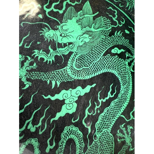 419A - A Chinese black background dish with green dragons to the body, with 6 character mark to the reverse... 