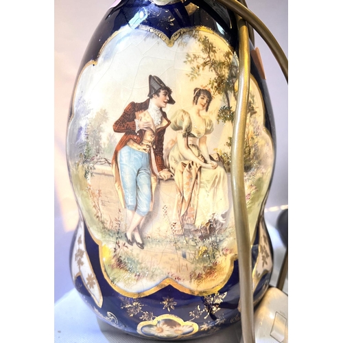 524 - A French ceramic converted oil lamp with traditional panel decoration, two Napoleonic soldiers and s... 