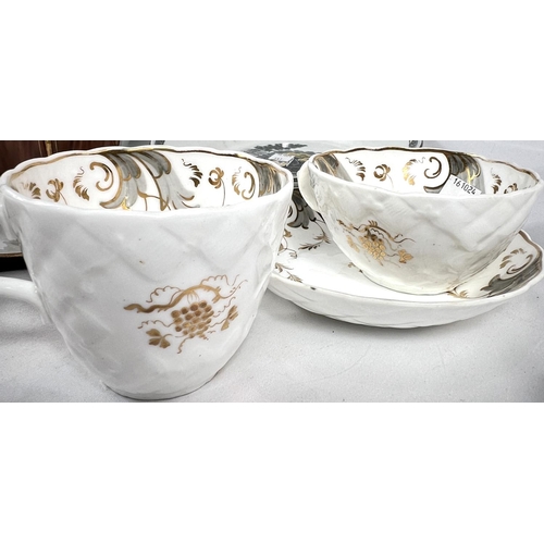 541 - An early Rockingham style trio set in grey and gilt, comprising a tea cup, coffee cup and saucer; a ... 