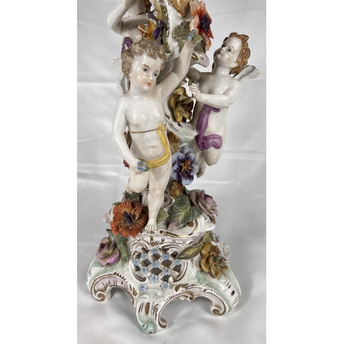 555 - A late 19th century DRESDEN porcelain table centre with naturalistic column with three putti on trif... 