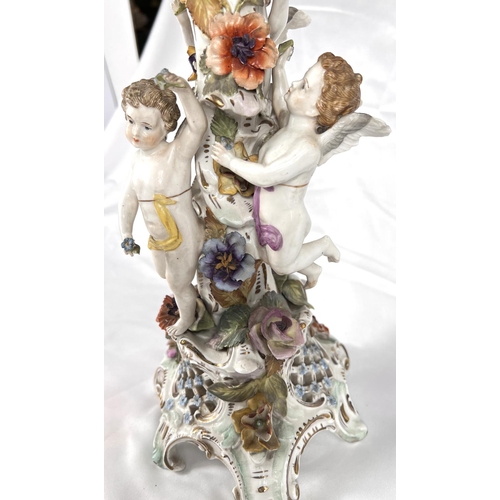 555 - A late 19th century DRESDEN porcelain table centre with naturalistic column with three putti on trif... 