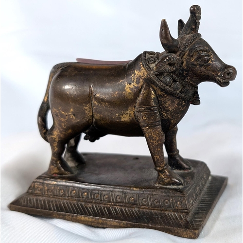 636 - A 19th century Indian gilt bronze Nandi Cow, length ....