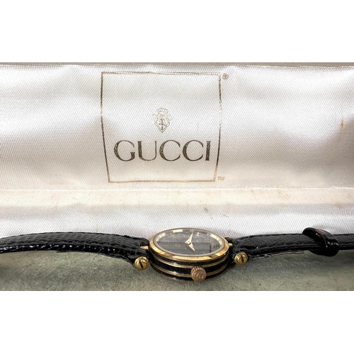 664 - GUCCI - a lady's wristwatch, quartz movement, original box and RAYMOND WEIL - a lady's wristwatch.