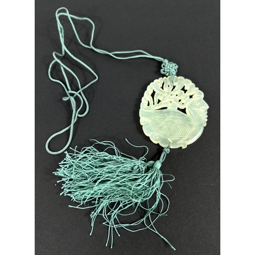 668 - A Chinese pale green hardstone pendant, 1930's with silk suspension and tassels.