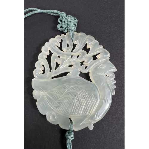 668 - A Chinese pale green hardstone pendant, 1930's with silk suspension and tassels.