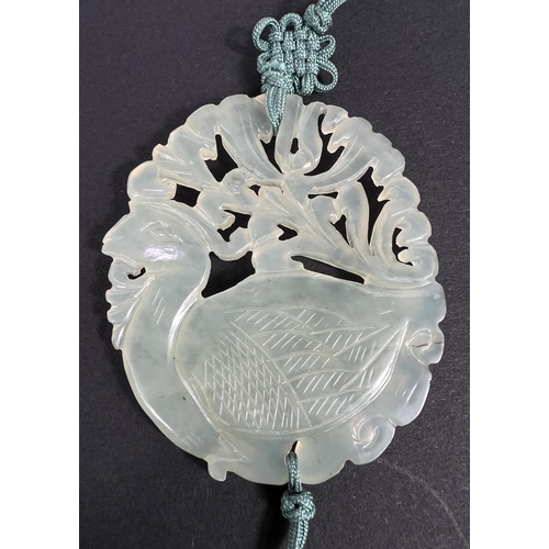 668 - A Chinese pale green hardstone pendant, 1930's with silk suspension and tassels.