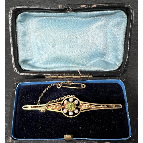 685 - An Edwardian peridot and pearl bar brooch, stamped 15ct, 4.0gms in original box.