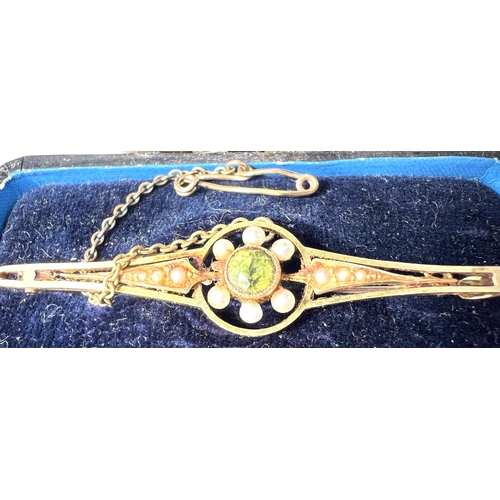 685 - An Edwardian peridot and pearl bar brooch, stamped 15ct, 4.0gms in original box.