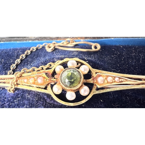 685 - An Edwardian peridot and pearl bar brooch, stamped 15ct, 4.0gms in original box.