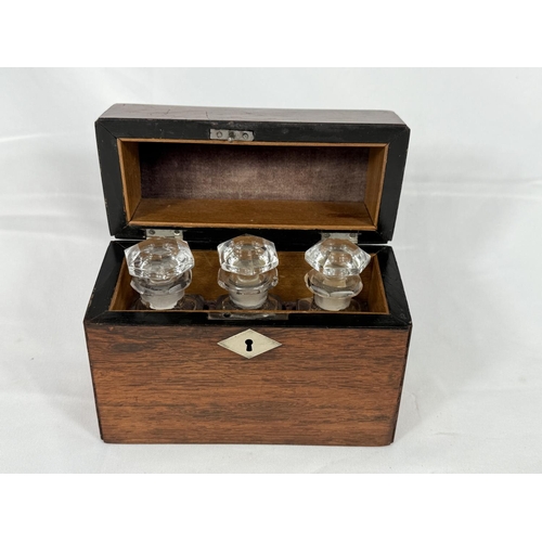 691 - A stained wood domed caddy fitted with three glass perfume bottles.