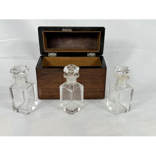 691 - A stained wood domed caddy fitted with three glass perfume bottles.