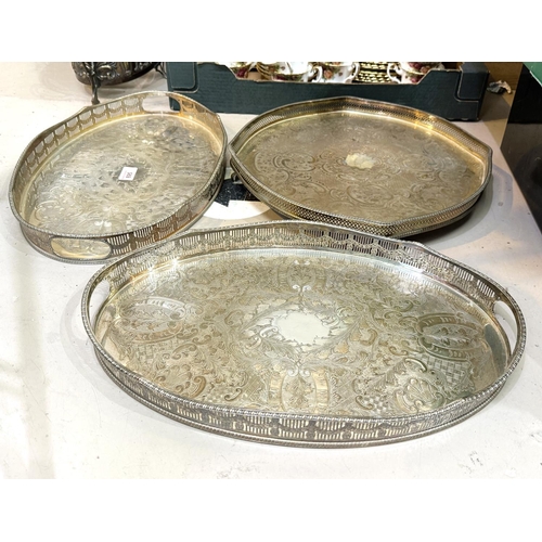 695 - A pair of chased oval silver on copper gallery trays and a circular tray.