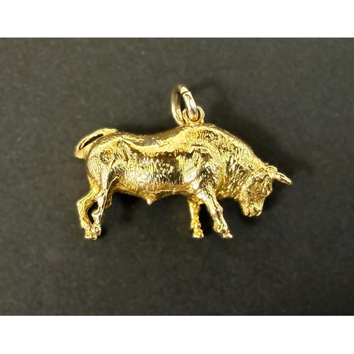 701 - An unmarked yellow metal charm in the form of a bull, 9gms.