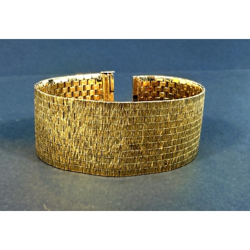 704 - A wide 9ct hallmarked gold bark effect bracelet, 69.5gms, length 18.5cm.