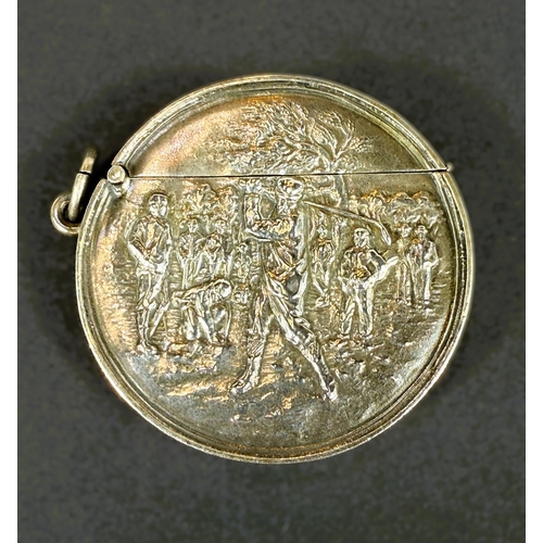 707 - An unusual circular hallmarked silver vesta case depicting a golfer in full swing, Birmingham 1906.