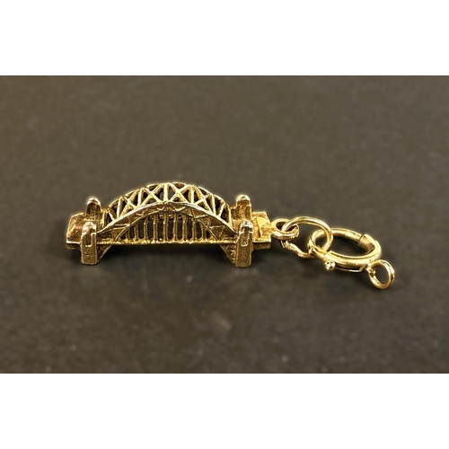 714 - A yellow metal charm in the form of (Sydney Harbour?) Bridge, stamped 9 ct, 2.4 gms.