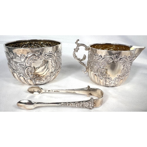 717 - A Goldsmiths & Silversmith company matching sugar, cream & tongs with extensive embossed dec... 