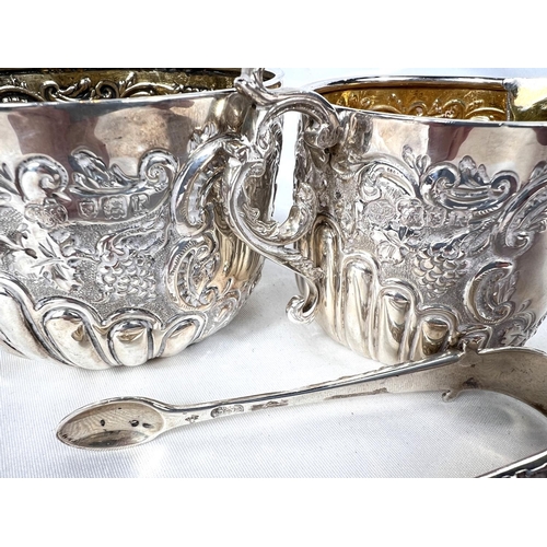 717 - A Goldsmiths & Silversmith company matching sugar, cream & tongs with extensive embossed dec... 