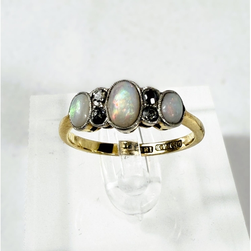 726 - A yellow metal dress ring set with 3 opals interspersed with 4 diamond chips, stamped 18ct, 2.4gms, ... 