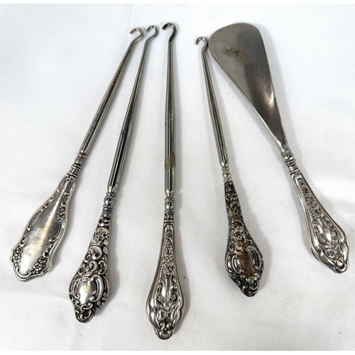 727 - A selection of four silver handle button hooks and a shoe horn, Chester hallmarks.