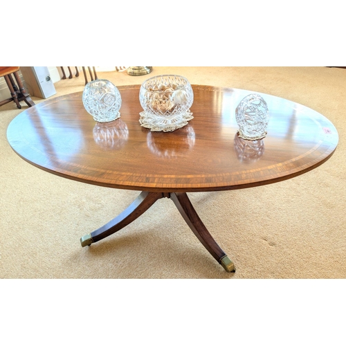 861 - A mahogany reproduction large inlaid oval coffee table with column on four splay feet, length 120cm.