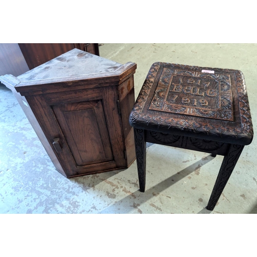 875 - A carved oak stool commemorating WWI and a small oak corner cupboard.