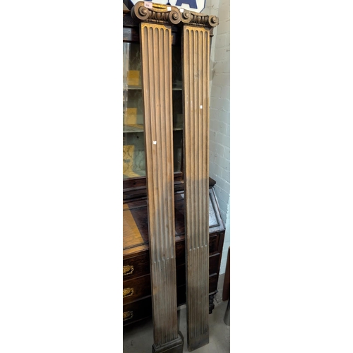 896 - A pair of late 19th century oak classical style pilasters with scroll surmounts, (a/f), 200cm.