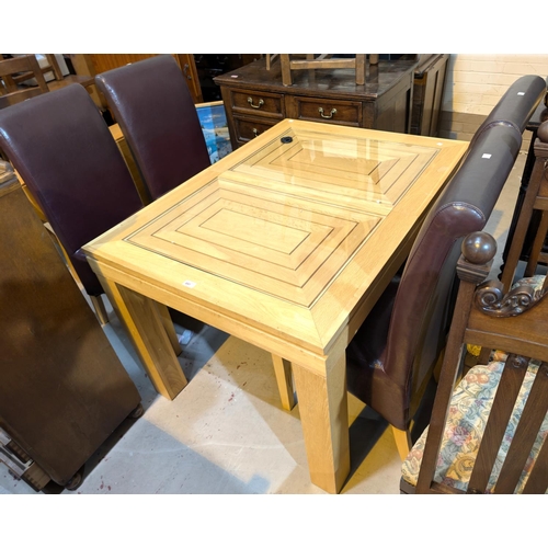 897 - A light oak extending dining table with single leaf and four high back dining chairs.