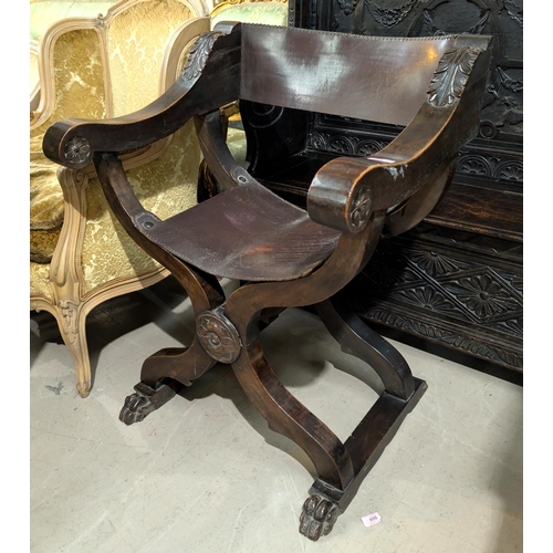 905 - A Neo Classical Italian style x framed arm chair with carved leaf and floral details, with claw feet... 