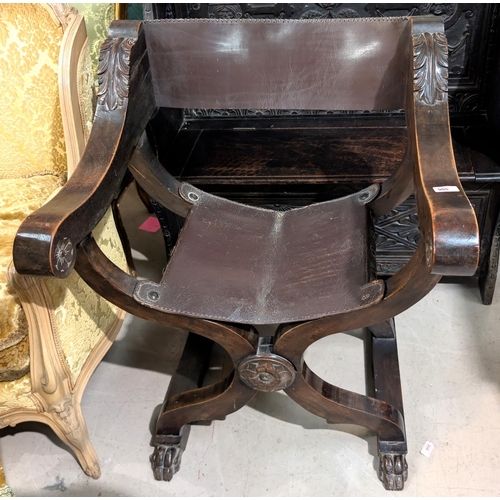 905 - A Neo Classical Italian style x framed arm chair with carved leaf and floral details, with claw feet... 