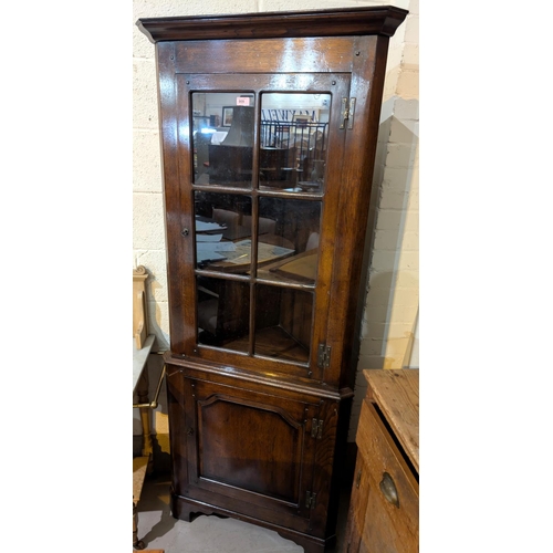 909 - An oak Titchmarsh and Goodwin full height corner cupboard, glazed door above and solid door below.